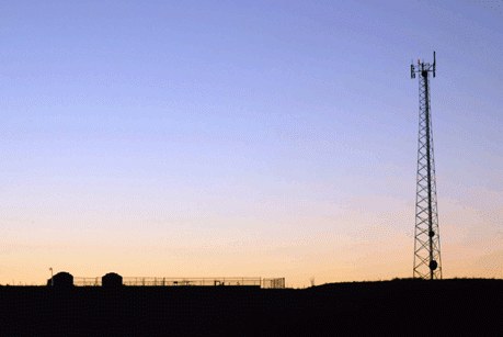 A communications tower silhouetted against a Hawaiian sunset.